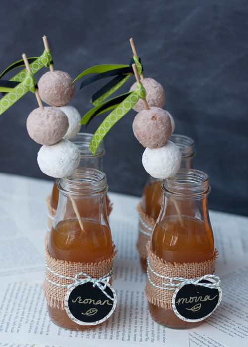 donuts on straws in glass of apple cider