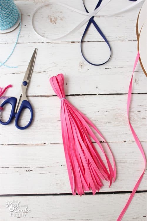 OMG! I need to make this adorable tassel photography backdrop. It is super simple to make and will be perfect for our Back to School pictures. 