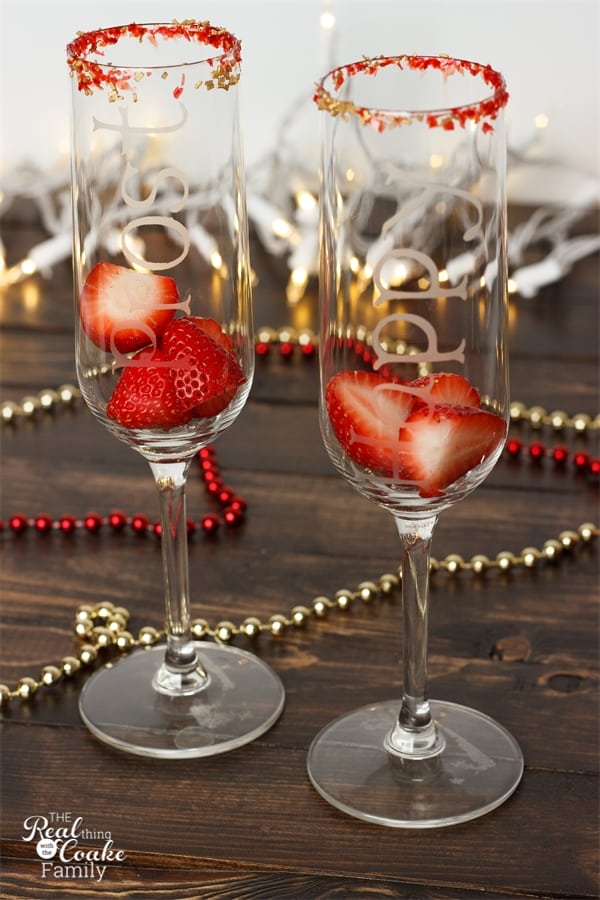 red and gold sanding sugar on rim of champagne flutes with strawberries in the flutes