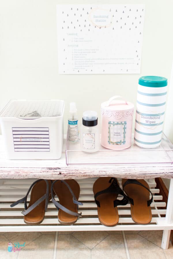 Shoe rack holding shoes on one shelf and containers for sanitizing station on other shelf